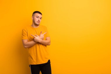 Şaşkın, kafası karışmış, kendine güveni olmayan ve zıt yönlere bakan genç ve yakışıklı bir adam.