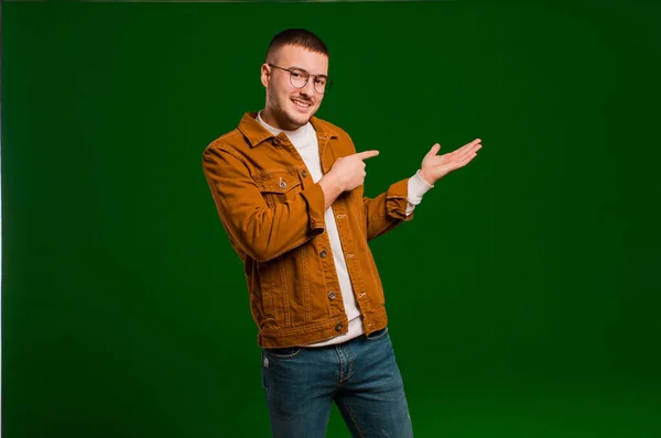 Jovem Homem Bonito Sorrindo Alegremente Apontando Para Copiar Espaço Palma — Fotografia de Stock