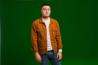Genç, yakışıklı bir adam üzgün ve stresli. Kötü bir sürpriz yüzünden üzgün. Düz zemine karşı olumsuz ve endişeli bir bakış.