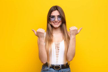 Genç ve güzel bir kadın neşeyle gülümsüyor ve mutlu görünüyor, kaygısız ve pozitif hissediyor.