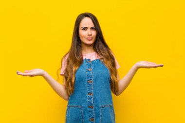 Genç, güzel bir kadın şaşkın ve kafası karışık, şüpheci, farklı seçenekleri tartıyor ya da komik bir ifadeyle seçiyor.