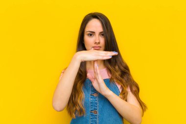 Genç ve güzel bir kadın ciddi, sert, kızgın ve hoşnutsuz görünüyor.