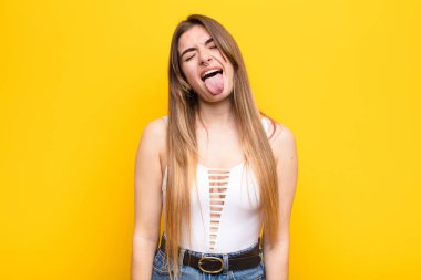 Neşeli, kaygısız, asi tavrıyla genç, güzel bir kadın şakalaşıyor ve dillerini çıkarıp eğleniyor.