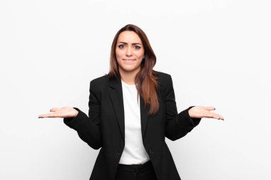 Genç, güzel bir iş kadını kendini cahil ve kafası karışık hissediyor. Hangi seçeneği seçeceğinden emin değil. Beyaz duvara karşı merak içinde.