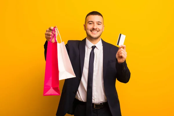 Joven Hombre Negocios Guapo Contra Fondo Plano Con Bolsas Compras —  Fotos de Stock