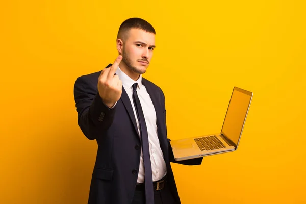 young handsome businessman  against flat background holding a laptop