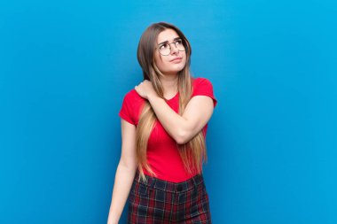 Genç, güzel bir kadın endişeli, hasta, hasta ve mutsuz hissediyor. Ağrılı bir mide ağrısı ya da mavi duvarda grip geçiriyor.