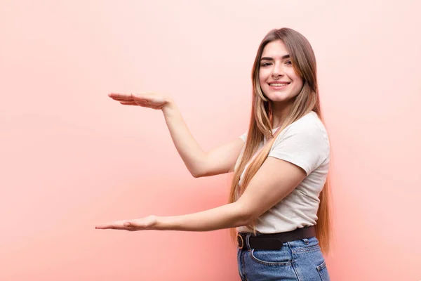 Joven Mujer Bonita Sosteniendo Objeto Con Ambas Manos Espacio Copia — Foto de Stock