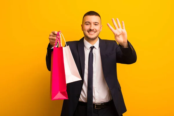 Joven Hombre Negocios Guapo Contra Fondo Plano Con Bolsas Compras —  Fotos de Stock