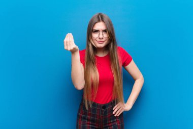 Genç ve güzel bir kadın sana borcunu ödemeni söyleyerek kapiş ya da para hareketi yapıyor! mavi duvara yaslan