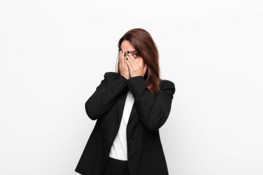 Genç ve güzel iş kadını korkmuş ya da utanmış hissediyor. Gözleri yarı kapalı beyaz duvara bakıyor ya da gözetliyor.