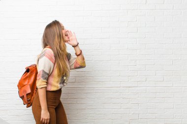 Genç ve güzel bir kadın profili, mutlu ve heyecanlı görünüyor, bağırıyor ve kenardaki boşluğu kopyalamak için arıyor.