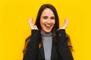 Genç ve güzel bir kadın beklenmedik bir iş ya da iş konsepti yüzünden şaşkın, heyecanlı, gülen, şaşkın ve mutlu hissediyor.