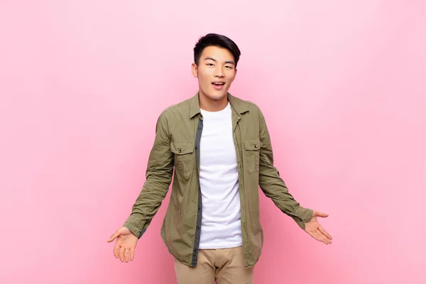 大きくてフレンドリーで屈託のない笑顔の若い中国人男性はポジティブでリラックスして幸せそうです平らな色の壁に対して冷静です — ストック写真