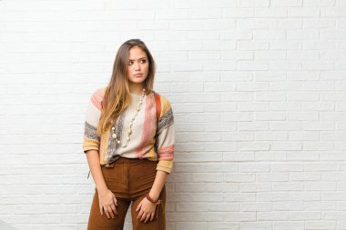 Genç, güzel bir kadın üzgün, üzgün ya da kızgın ve olumsuz bir tavır takınıyor, anlaşmazlık içinde kaşlarını çatıyor.