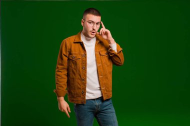 Genç yakışıklı adam şaşırmış, ağzı açık, şok olmuş, düz arkaplan karşısında yeni bir düşünce, fikir ya da konsept fark ediyor.