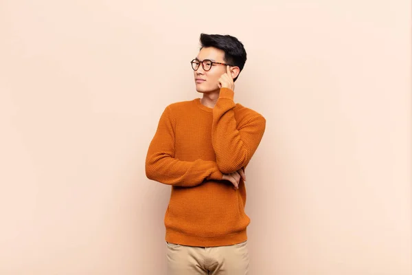 Young Chinese Man Concentrated Look Wondering Doubtful Expression Looking Side — Stock Photo, Image