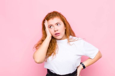 Genç kızıl saçlı kadın, yorgun, sıkıcı ve sıkıcı bir görevin ardından sıkılmış, hayal kırıklığına uğramış ve uykulu hissediyor.