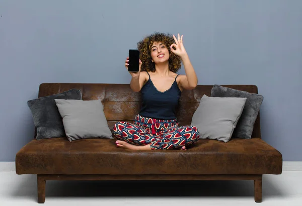 Joven mujer bonita en casa, con un teléfono móvil, usando pijamas — Foto de Stock