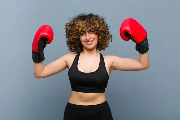 young pretty sports woman wearing fitness clothes and boxing gloves