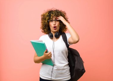 Genç ve güzel bir bayan öğrenci. Mutlu, şaşkın ve şaşırmış görünüyor. Gülümsüyor ve fark ediyor.