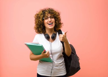 Genç ve güzel bir bayan, mutlu, pozitif, kendine güvenen ve başarılı bir şekilde gülümsüyor.