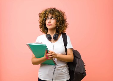 Genç ve güzel bir bayan öğrenci. Düşünceli, meraklı ya da hayal kuruyor. Hayal kuruyor ve pembe duvara karşı boşluğu doldurmaya çalışıyor.