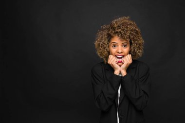 Düz duvara karşı Afro-Amerikan genç kadın.