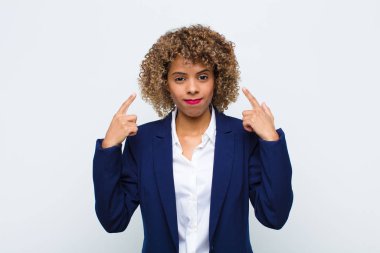 Kötü tavırlı, gururlu ve agresif görünen, yukarıyı gösteren ya da duvara yaslanmış ellerle alay eden Afro-Amerikan genç kadın.