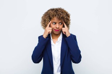 Afrika kökenli Amerikalı genç bir kadın bir fikre odaklanmış ve kafa yoruyor, düz duvara karşı bir meydan okuma ya da soruna bir çözüm hayal ediyor.