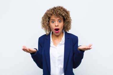 Genç Afro-Amerikan kadını şok olmuş, şaşırmış, endişeli ve paniklemiş, stresli ve dehşete düşmüş bir şekilde düz duvara bakıyor.