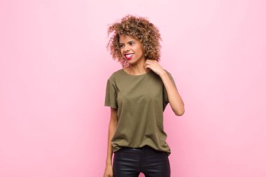 Genç Afrikalı Amerikalı kadın kendini stresli, endişeli, yorgun ve hayal kırıklığına uğramış hissediyor. Pembe duvara karşı sorunlu görünüyor.