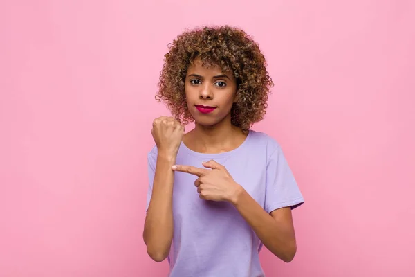 若いアフリカ系アメリカ人女性は焦りと怒りの表情で時間通りにピンクの壁に対峙したがっています — ストック写真
