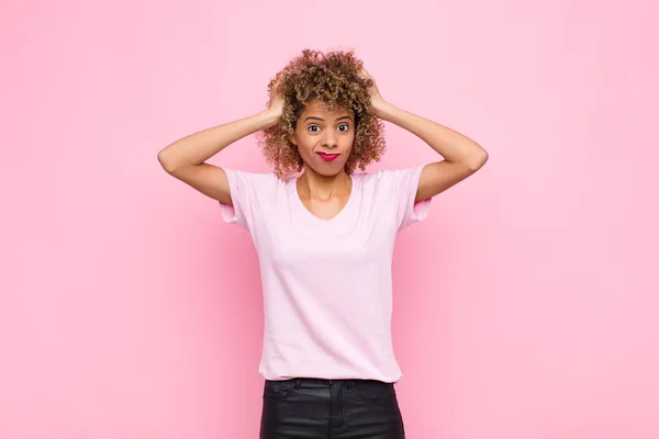 若いアフリカ系アメリカ人女性はフラストレーションを感じていらいらし 病気になり 失敗に疲れて ピンクの壁に対して鈍い退屈なタスクでうんざりしています — ストック写真