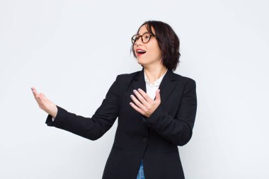 Genç iş kadını opera yapıyor ya da bir konserde şarkı söylüyor, romantik, sanatsal ve tutkulu hissediyor beyaz duvara karşı