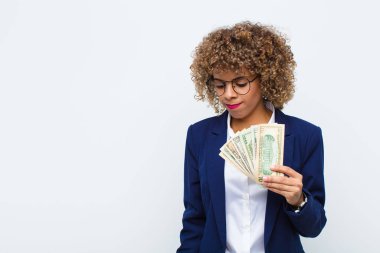 Genç Afrikalı Amerikalı kadın üzgün, üzgün ya da kızgın ve olumsuz bir tavır takınıyor. Avro banknotlarıyla anlaşmazlık içinde.