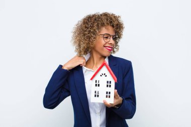 Genç Afrikalı Amerikalı kadın stresli, endişeli, yorgun ve hayal kırıklığına uğramış, gömleğini çekmiş, ev modeli ile ilgili sorunlardan bıkmış görünüyor.