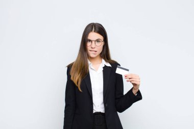 Genç ve güzel bir kadın şaşkın ve kafası karışmış görünüyor. Sinirli bir hareketle dudağını ısırıyor. Kredi kartıyla sorunun cevabını bilmiyor.