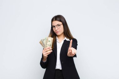 Genç ve güzel bir kadın gururla gülümsüyor ve gururla bir numaralı pozu veriyor. Kendini banknotları olan bir lider gibi hissediyor.