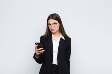 Genç ve güzel bir kadın üzgün ve mızmızlanıyor, mutsuz bir bakışla, negatif ve hayal kırıklığına uğramış bir tavırla ağlıyor cep telefonuyla.