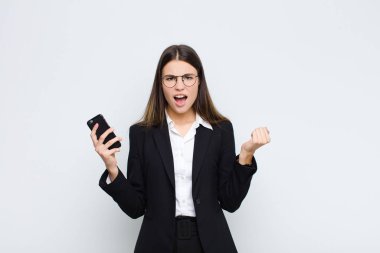 Genç ve güzel bir kadın öfkeli bir ifadeyle ya da cep telefonuyla başarıyı kutlayan yumruklarla agresif bir şekilde bağırıyor.