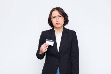 Genç, güzel bir kadın üzgün ve mızmızlanıyor, mutsuz bir bakışla ağlıyor, olumsuz ve hayal kırıklığına uğramış bir tavırla kredi kartıyla ağlıyor.