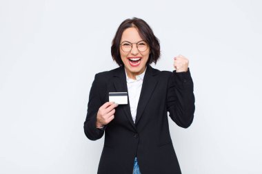 Genç ve güzel bir kadın öfkeli bir ifadeyle ya da kredi kartıyla başarıyı kutlayan yumruklarla agresif bir şekilde bağırıyor.