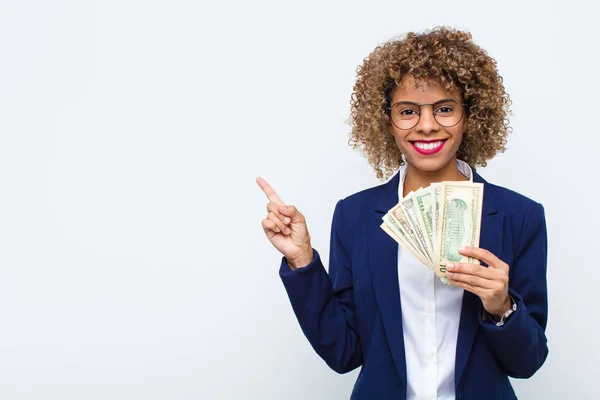 アフリカ系アメリカ人の若い女性が陽気に笑顔を浮かべ 幸せを感じ 横と上を指差して ユーロ紙幣のコピースペースに物を見せ — ストック写真