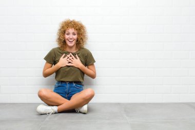 Genç afro kadın mutlu, şaşırmış, gururlu ve heyecanlı görünüyor.