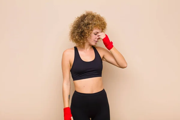 young afro woman feeling stressed, unhappy and frustrated, touching forehead and suffering migraine of severe headache sport concept