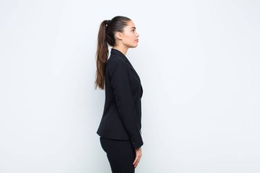 Profil görünümünde genç, güzel bir kadın ileriyi kopyalamak istiyor. Düşünüyor, hayal ediyor ya da hayal kuruyor.