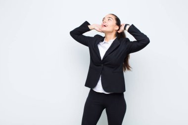 Genç ve güzel bir kadın gülümsüyor ve rahatlıyor, tatmin oluyor ve kaygısız, olumlu ve ürpertici iş konsepti gülüyor.