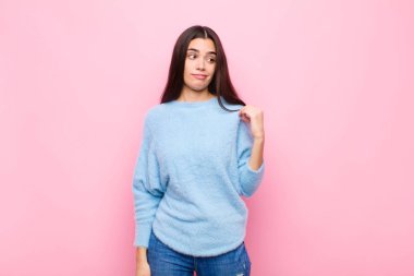 Genç, güzel bir kadın kibirli, başarılı, pozitif ve gururlu görünüyor. Kendini pembe duvara gösteriyor.