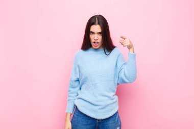 Genç, güzel bir kadın, kızgın agresif bir ifadeyle kameraya bakıyor. Öfkeli, çılgın bir patrona benziyor.